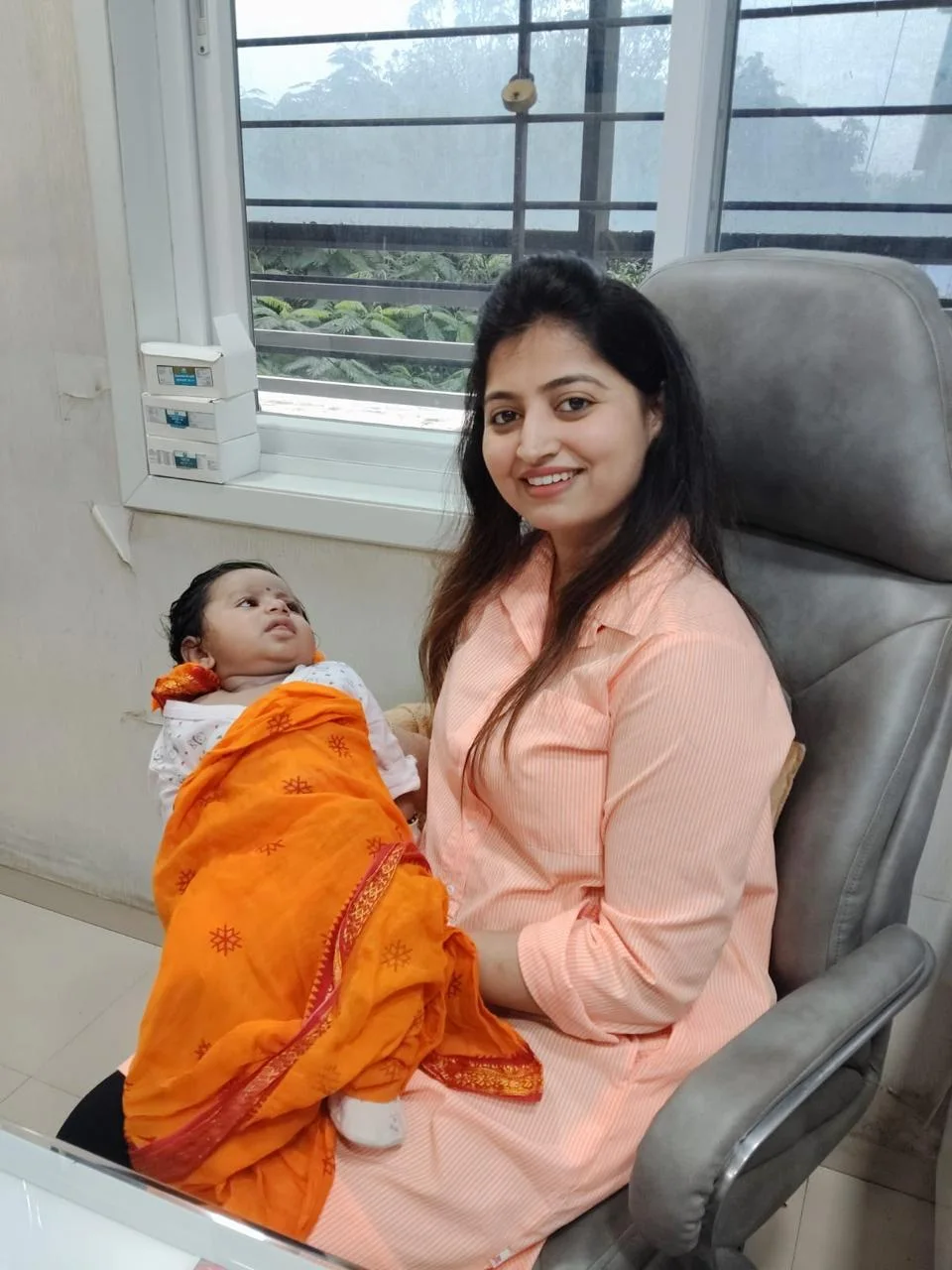 Real clinic photograph of Dr Mayuri Avhad-Wagh holding a sleeping baby