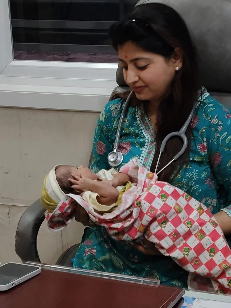Real clinic photograph of Dr Mayuri Avhad-Wagh holding a newborn